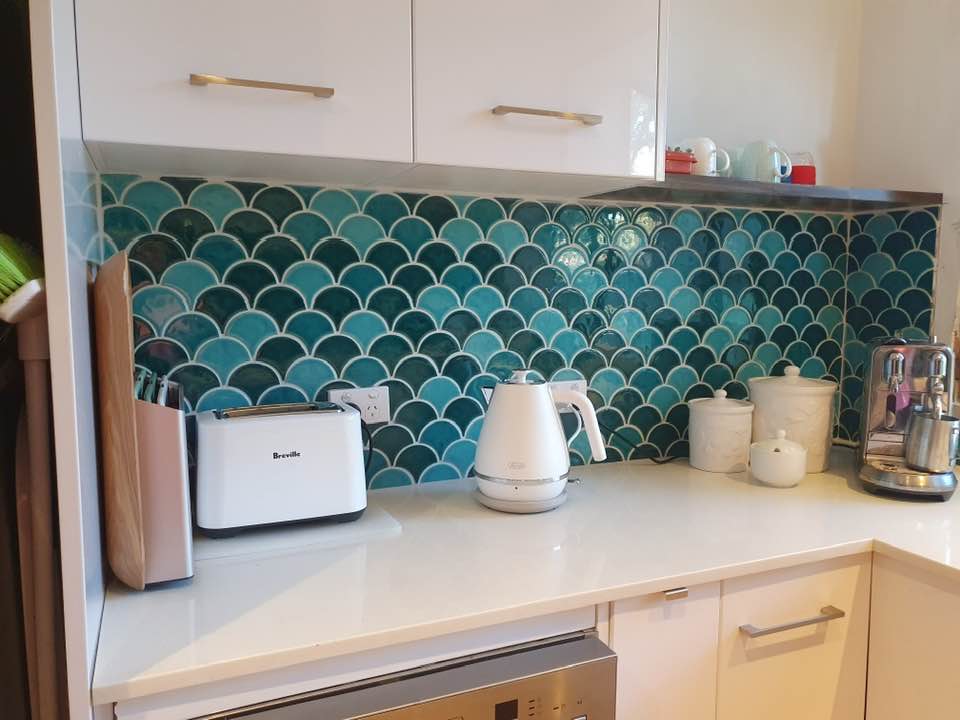 Teal fish-scale tile kitchen splashback